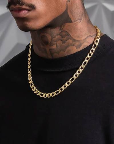 Man wearing a gold Figaro chain, showing the repeating three-short-one-long link pattern